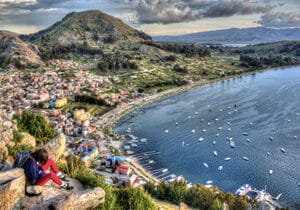 Shoreline of a city in Bolivia, dotted by boats in the ocean - safest countries in South America