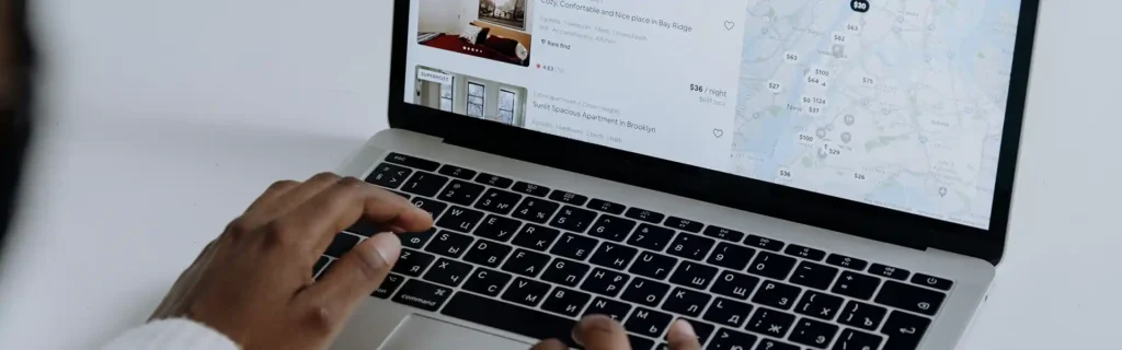 person using the computer to look for properties in airbnb