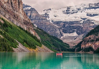 Red boat floating in Lake Louise in Alberta Canada - Best Country to Immigrate from India