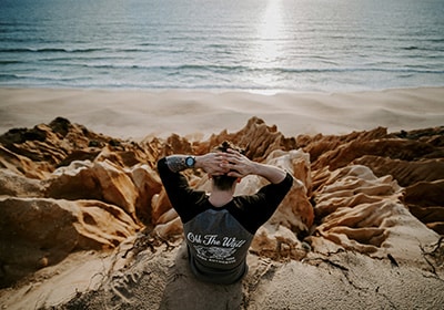 a man sitting on the beach in melides portugal 