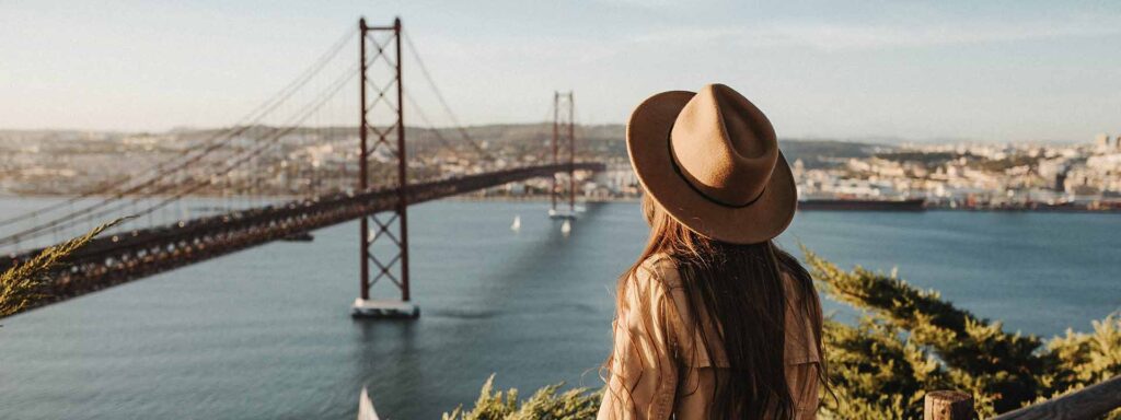 Woman overlooking the main bridge in Lisbon, Portugal - safest countries for women