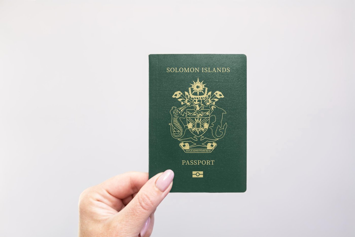 person holding a solomon islands passport against a white background