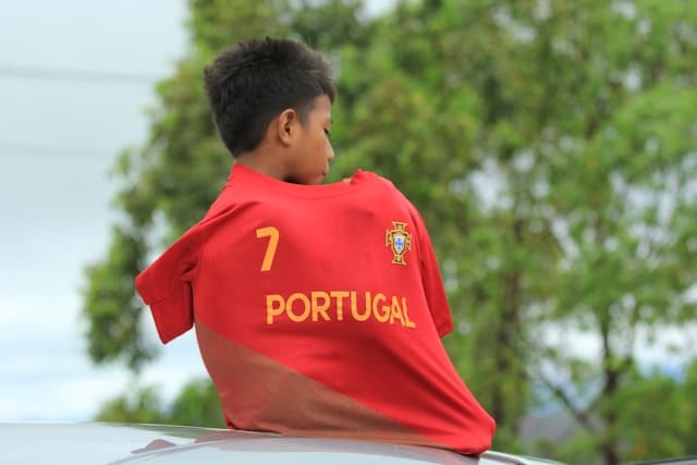 Portuguese child wearing a Portugal national football jersey