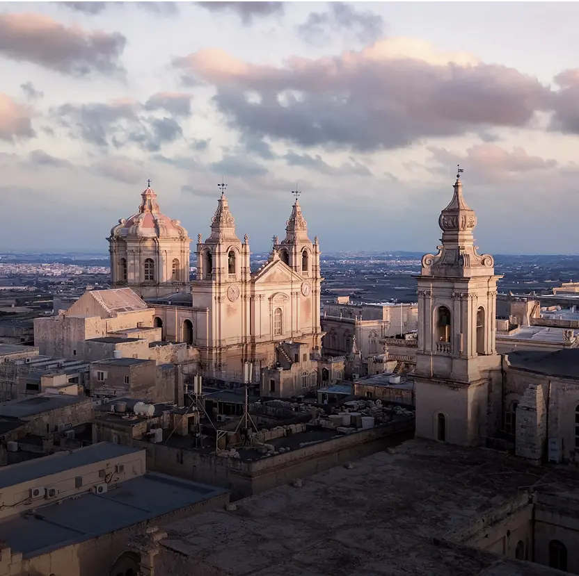 Valletta, Malta, showcasing historic architecture and vibrant city life against a clear blue sky.