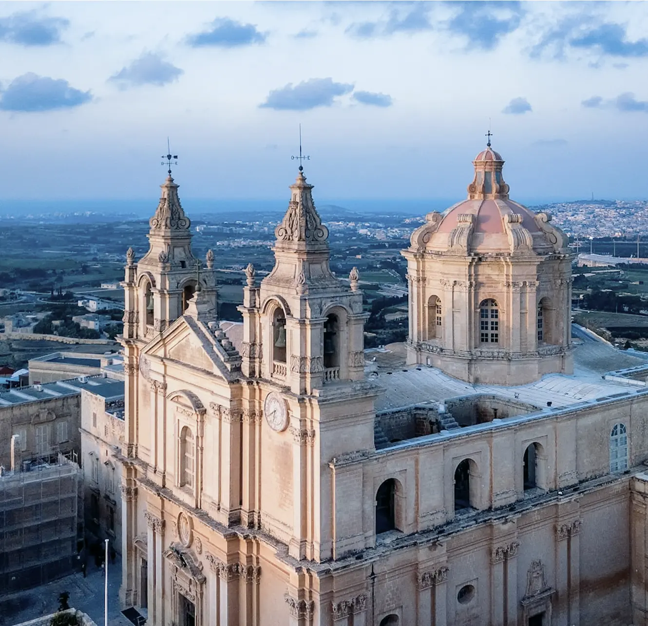 Aerial view of a church surrounded by urban buildings in a bustling city landscape.
