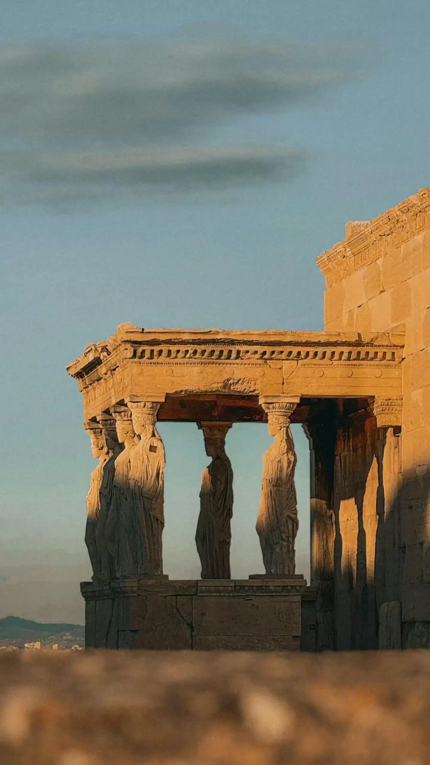 A building topped with ornate statues, showcasing intricate designs against a clear blue sky.