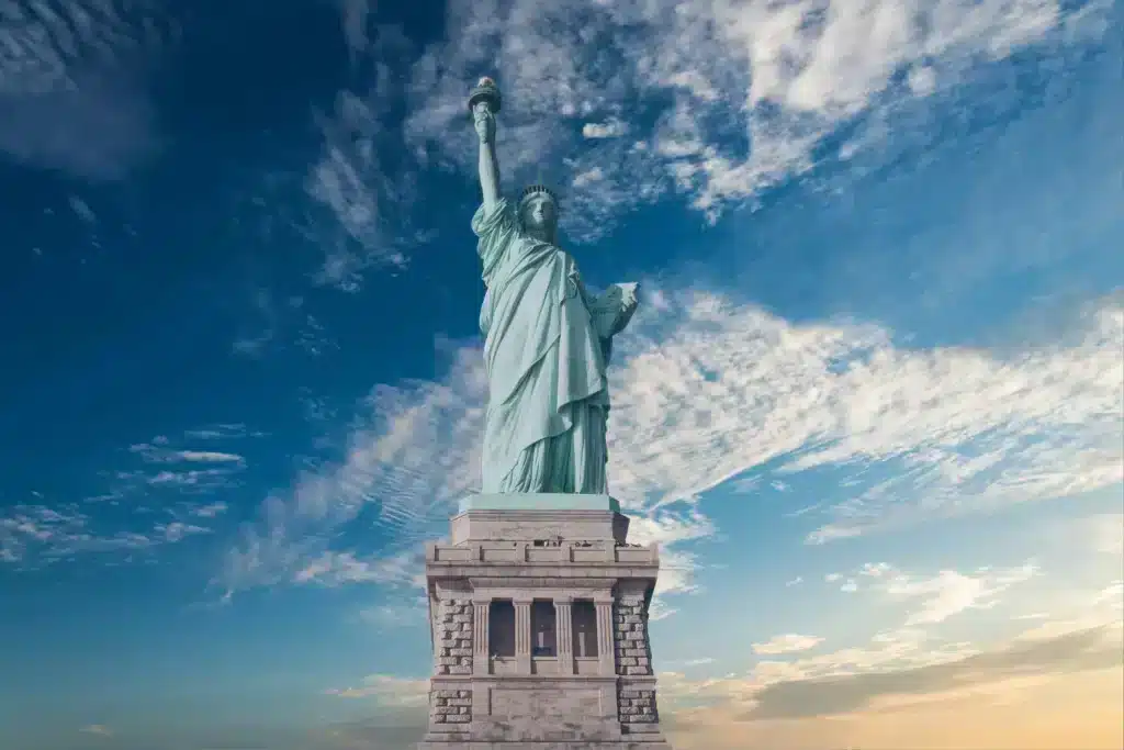 The Statue of Liberty stands proudly atop a hill, symbolizing freedom and hope against a clear blue sky.