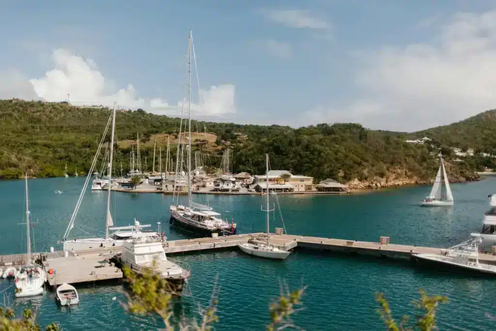 A marina filled with numerous sailboats docked peacefully in the water under a clear blue sky.