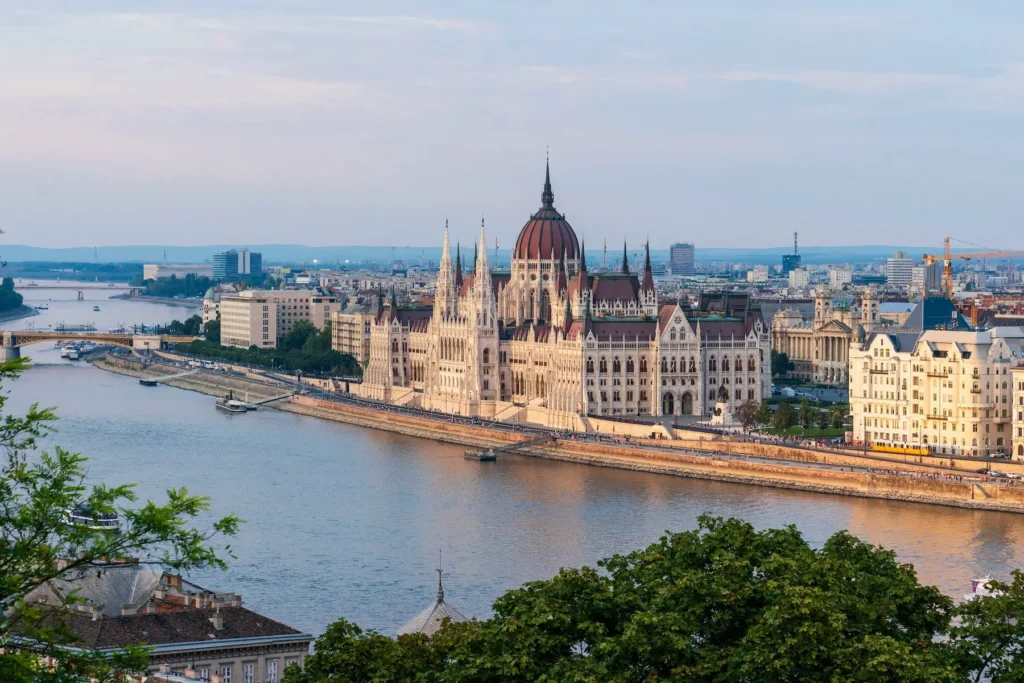 Hungarian Parliament Building prominently displayed in the background against a clear blue sky.