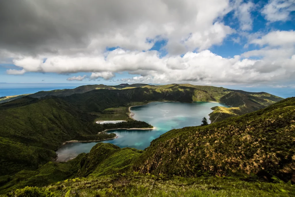 Scenic view of the Azores islands in Portugal, showcasing lush greenery and dramatic coastal cliffs under a clear blue sky.