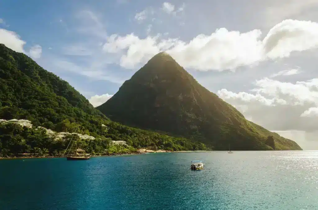 A scenic view of the Piton mountain in St. Lucia, showcasing its lush greenery and dramatic peaks against a clear sky.