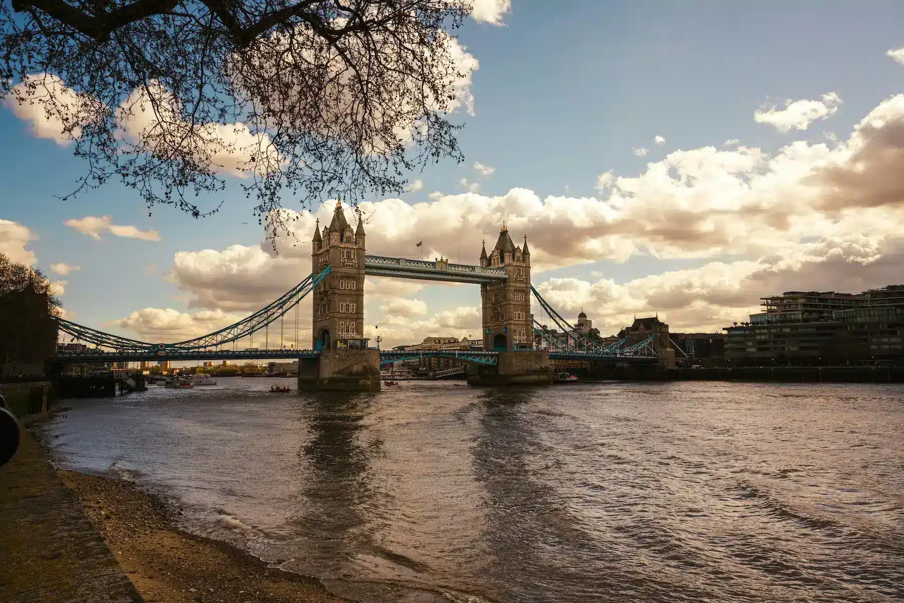 Tower Bridge in London, England, showcasing its iconic twin towers and suspension design against a clear blue sky.