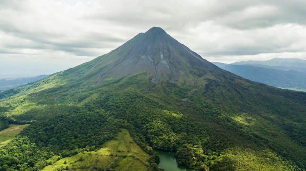 A mountain landscape featuring a prominent green mountain at its center, surrounded by rugged terrain in Costa Rica - best countries for US citizens to move to