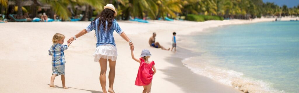 uma família a passear pela praia nas Caraíbas