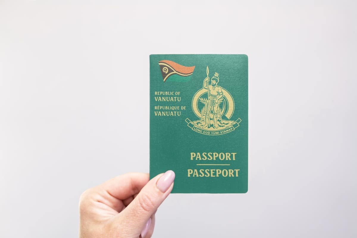 person holding a vanuatu passport against a white background