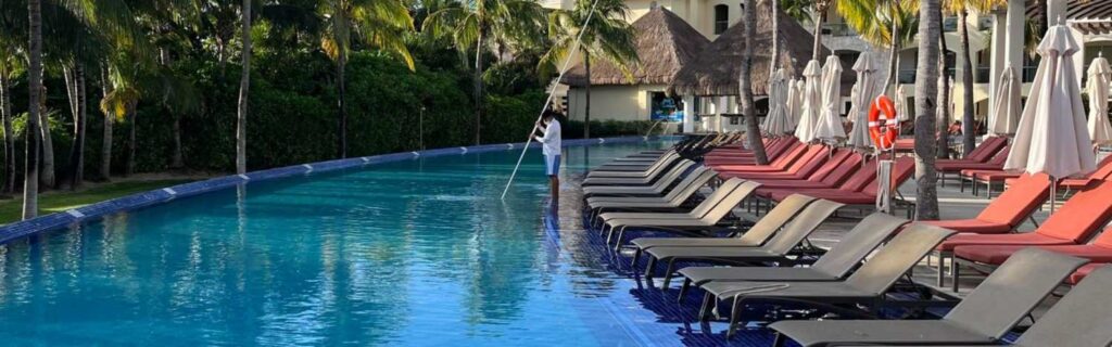 worker cleaning a hotel pool in st kitts