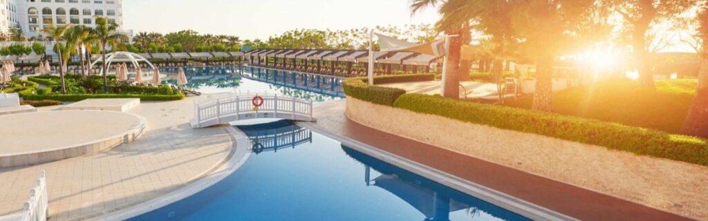 sunset from a pool and luxury hotel building in the cayman islands