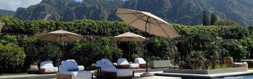 luxury hotel deck chairs and a pool with mountains in the background
