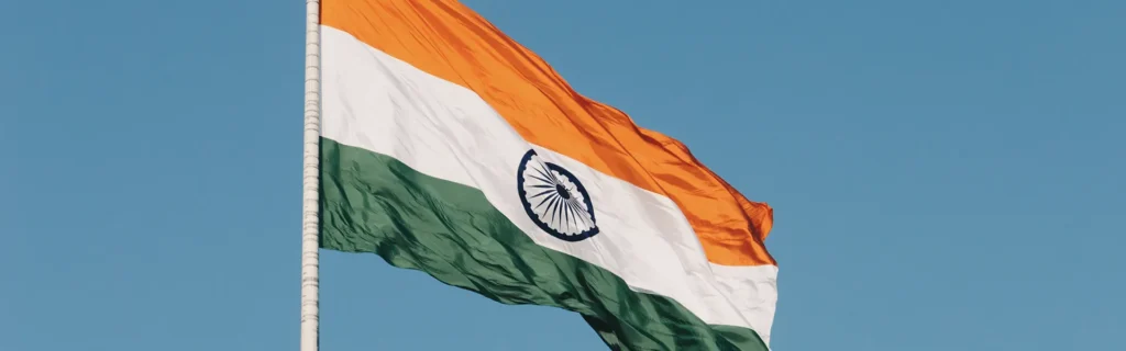 Indian flag waving against a bright blue background - Rise of Indian Entrepreneurs Holding Multi-Residency