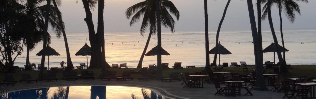 sunset view of palm trees and pool at Iririki Island Resort & Spa in vanuatu