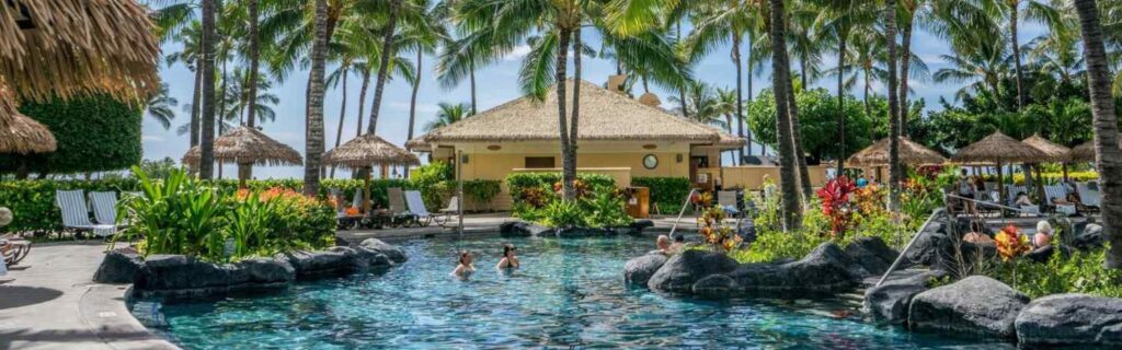 guest swimming in pool surrounded by palm trees at Warwick Le Lagon in Vanuatu