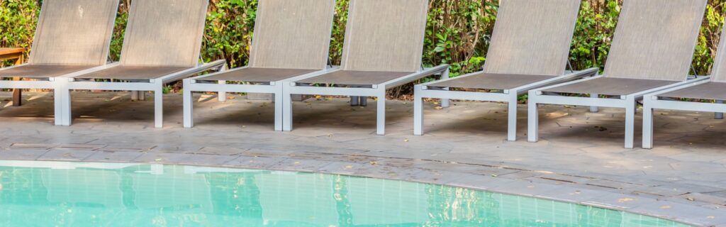 pool with deck chairs at naur's Aquariri Lodge