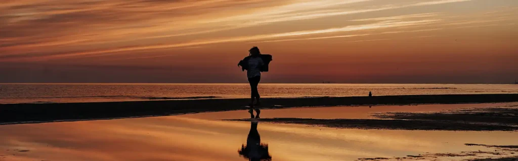 Woman walking on a beach in Latvia at sunset