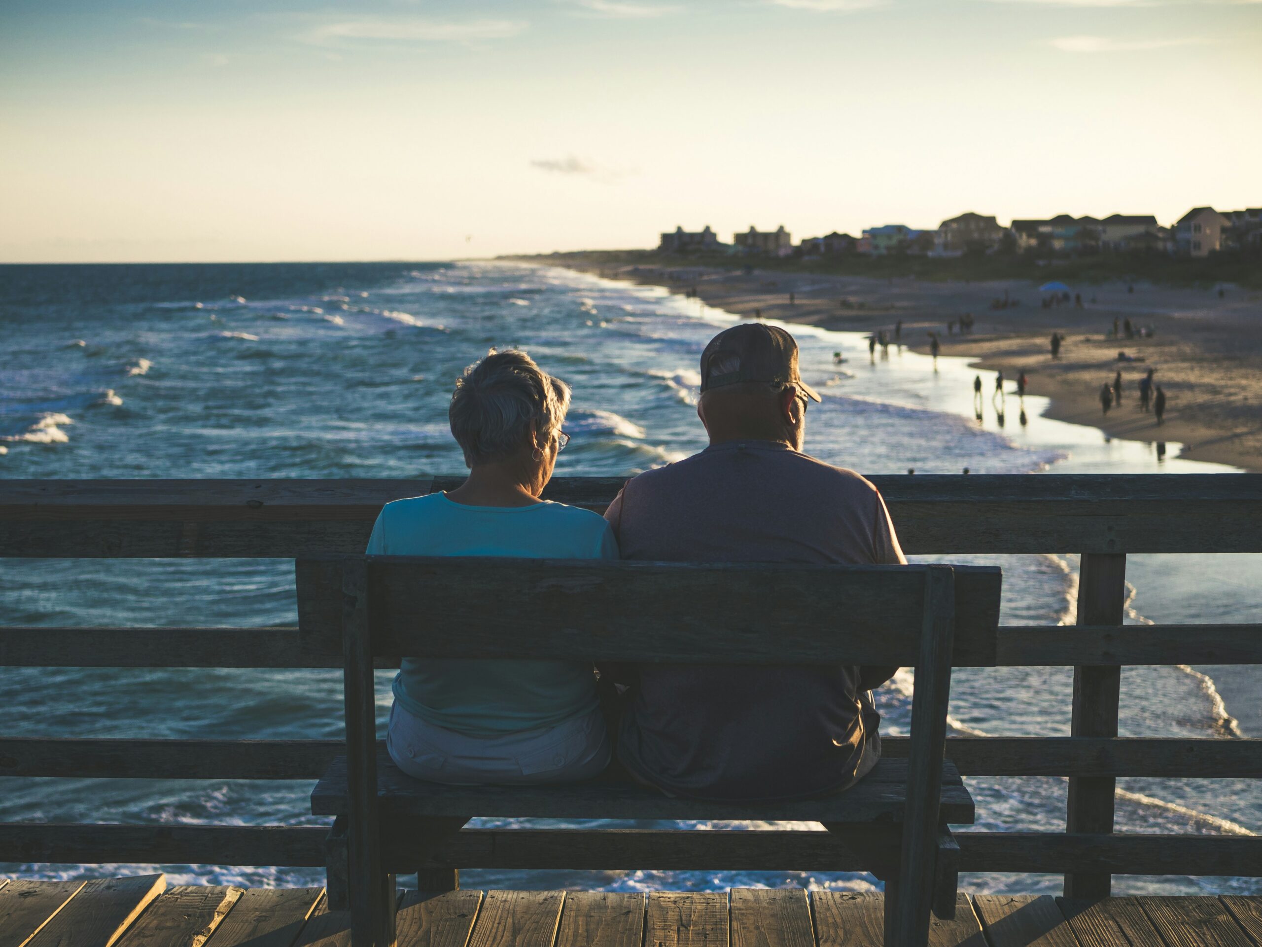 mature couple looking at the ocean sitting on a bench